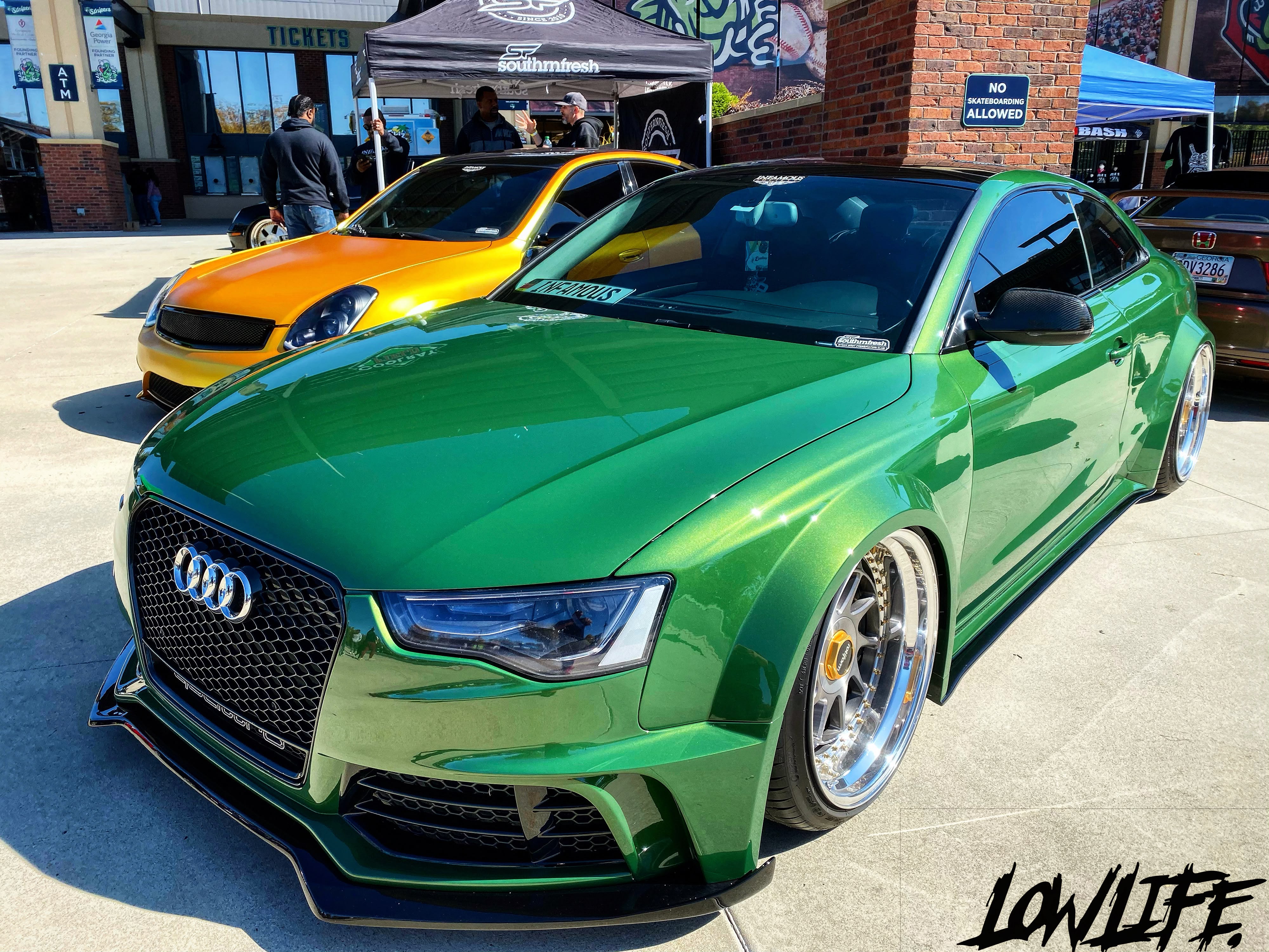 Green Audi and orange Infiniti at a daytime meet